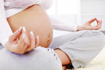 Close-up of a pregnant woman doing yoga.