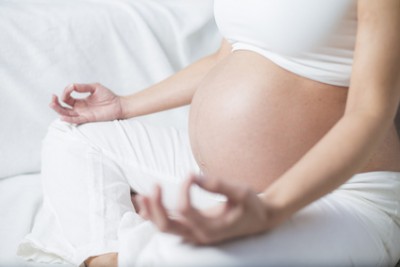 Schwangere Frau sitzend beim Yoga